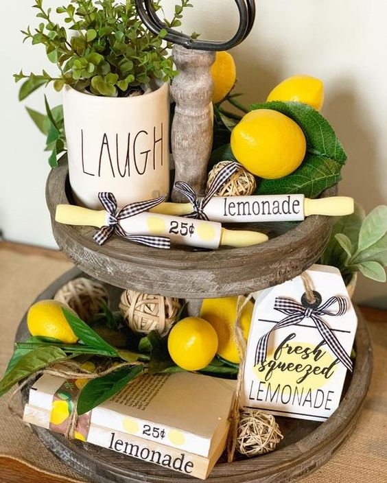 a wooden stand with faux lemons, greenery and potted greenery plus some lemonade signs for a spring feel