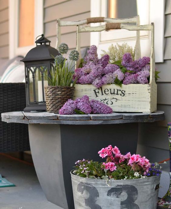 bold blooms in a tool box and in a galvanized bucket plus candle lanterns for a bright spring porch