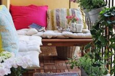 colorful pillows and a boho rug, potted greenery and flowers are bold and cool for a rustic-like balcony