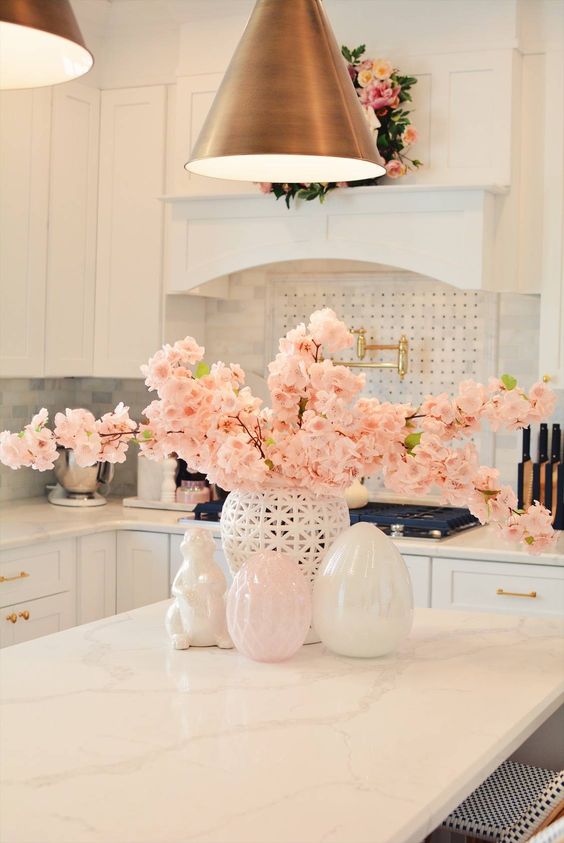 Fresh pink blooming branches in a vase and a matching pink wreath make the space look spring like