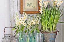 fresh white spring blooms in bottles and jars plus eggs on the table will give an Easter hint to your kitchen decor
