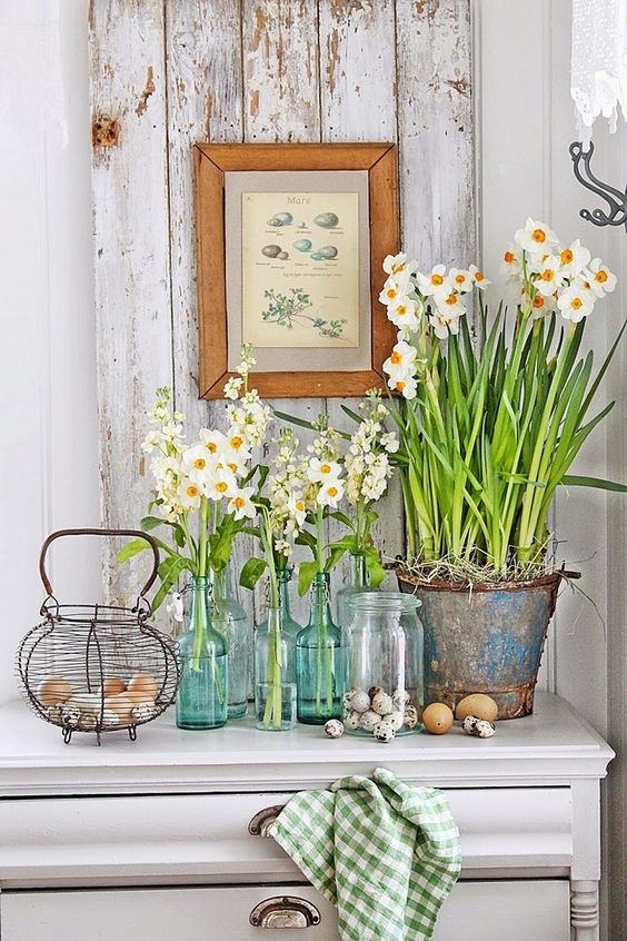fresh white spring blooms in bottles and jars plus eggs on the table will give an Easter hint to your kitchen decor