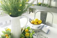 lemons in a bowl, a greenery and lemon wreath, greenery and yellow blooms in a jar make the space look spring-like