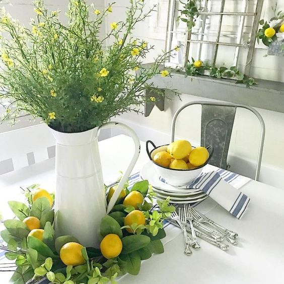 Lemons in a bowl, a greenery and lemon wreath, greenery and yellow blooms in a jar make the space look spring like