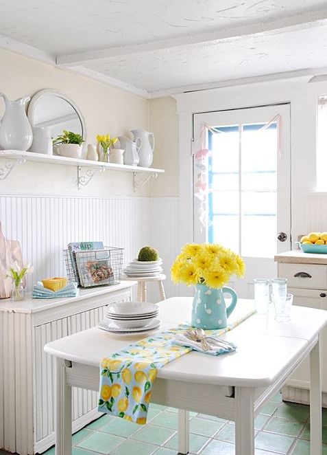 light blue linens, a jug with yellow blooms and some yellow touches make the kitchen spring-like