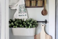 planters and pots with fresh greenery and printed towels make the kitchen fresh and spring-like and do that with style