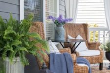 potted ferns, purple blooms in a churn, wicker chairs and candle lanterns for a farmhouse spring porch