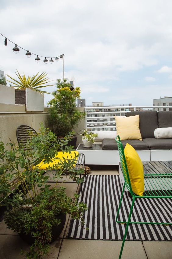 potted greenery and flowers and some sunny yellow touches will enliven even the most laconic balcony