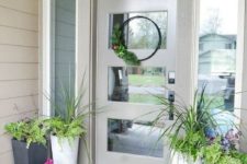 potted greenery, bright blooms and a greenery wreath for a bright spring porch