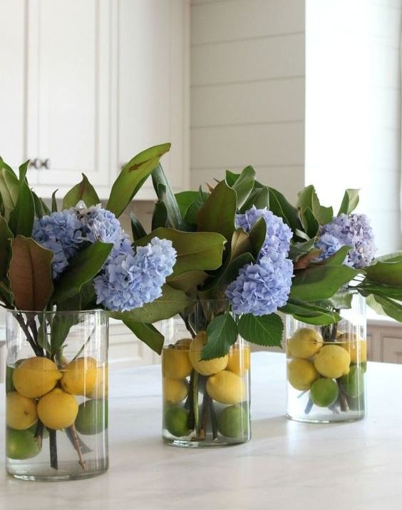 vases with magnolia leaves, blue hydrangeas, lemons and limes add a bright sprign touch to the space