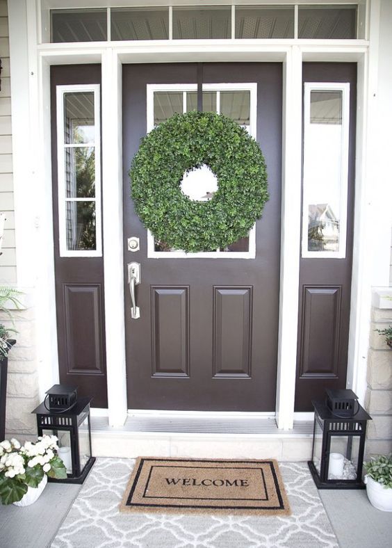 white potted blooms, a boxwood wreath and candle lanterns for a fresh and cool porch