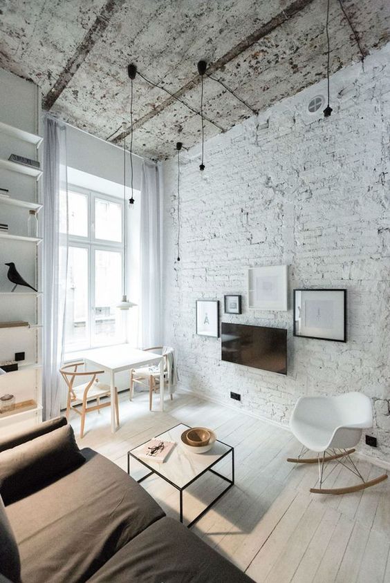 a Nordic living room with a whitewashed brick wlal and a shabby chic ceiling that bring eye-catchiness to the space and make it bold