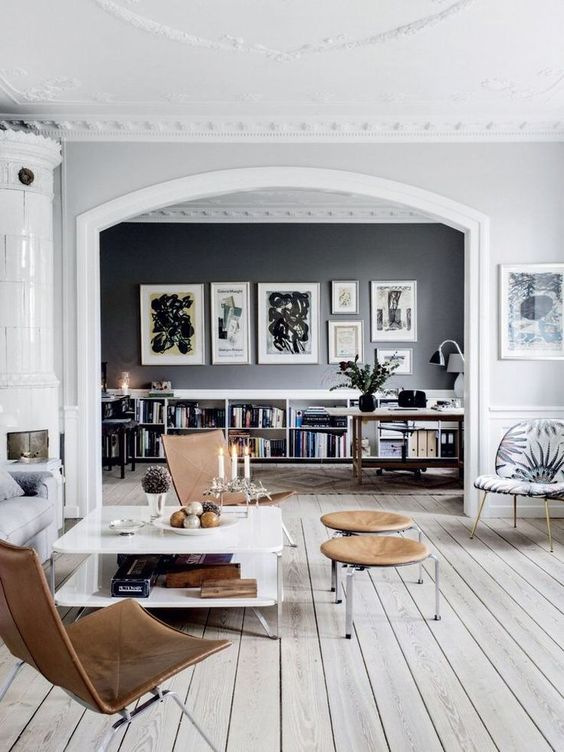a Scandinavian home with white and black walls, a whitewashed floor and mid-century modern furniture