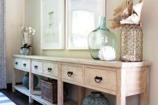 a beautiful and large whitewashed console table with drawers and a long open shelf is great for storage and displaying stuff