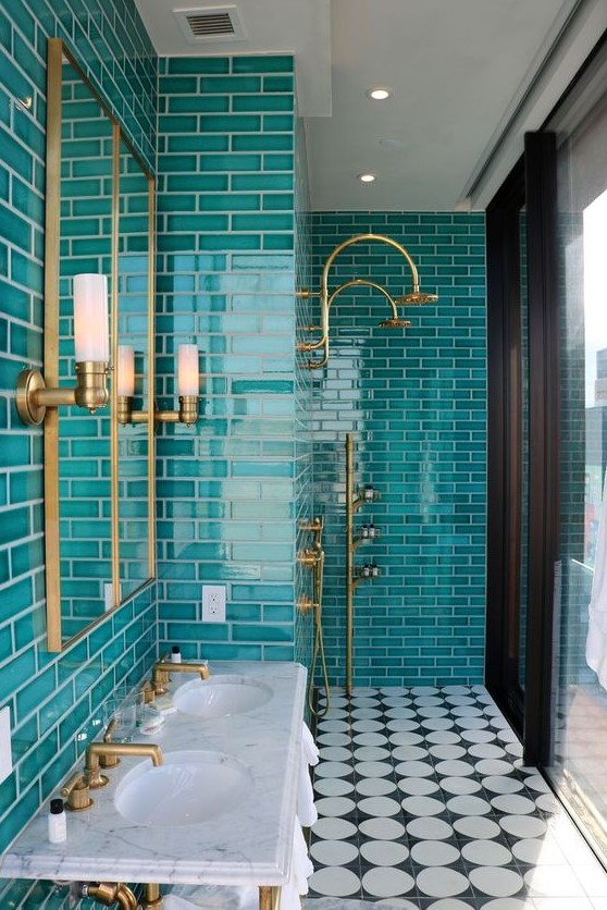 a chic modern bathroom with turquoise tiles, a white free-standing sink, mirrors and touches of gold