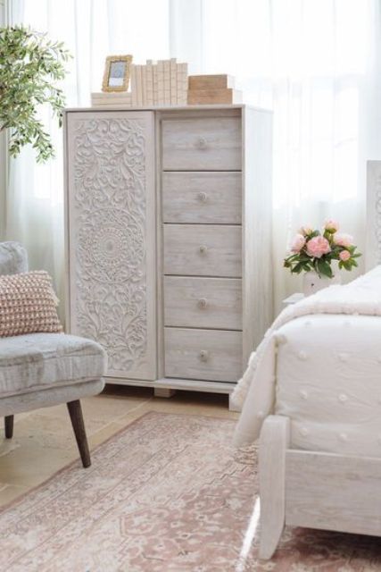 a delicate whitewashed storage unit with five drawers and a beautiful carved door is a lovely solution for a shabby chic bedroom