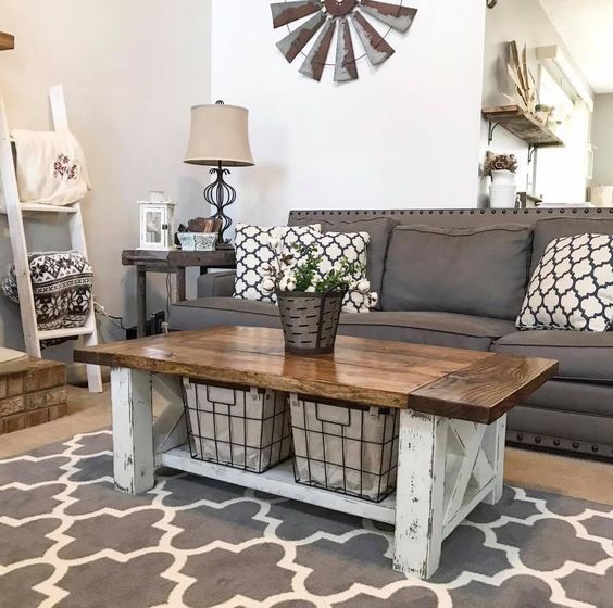 a farmhouse living room with a graphite grey sofa, a ladder for hanging stuff, a whitewashed and stained coffee table, printed textiles is all cool