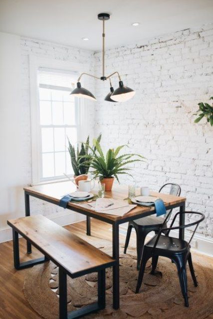 a modern dining zone with whitewashed brick walls, a chic dining set and metal chairs and a retro chandelier