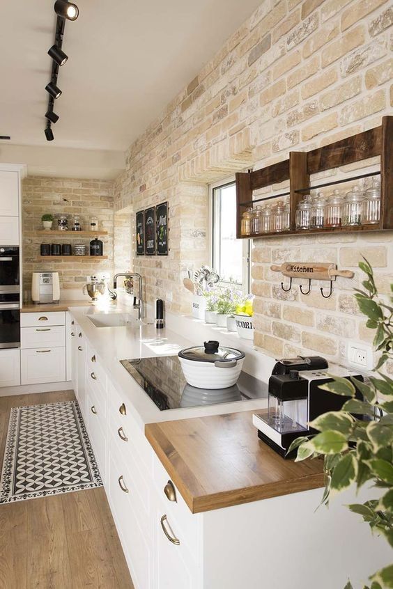 a modern farmhouse kitchen with whitewashed brick walls, sleek white cabinets is a very elegant and cool