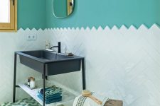 a refined bathroom with turquoise walls, a white tile backsplash, a navy sink on a stand and some touches of wood