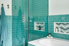 a stylish modern bathroom in white and with turquoise tiles looks contrasting and bright, and niches in the wall are done with green and white tiles, too