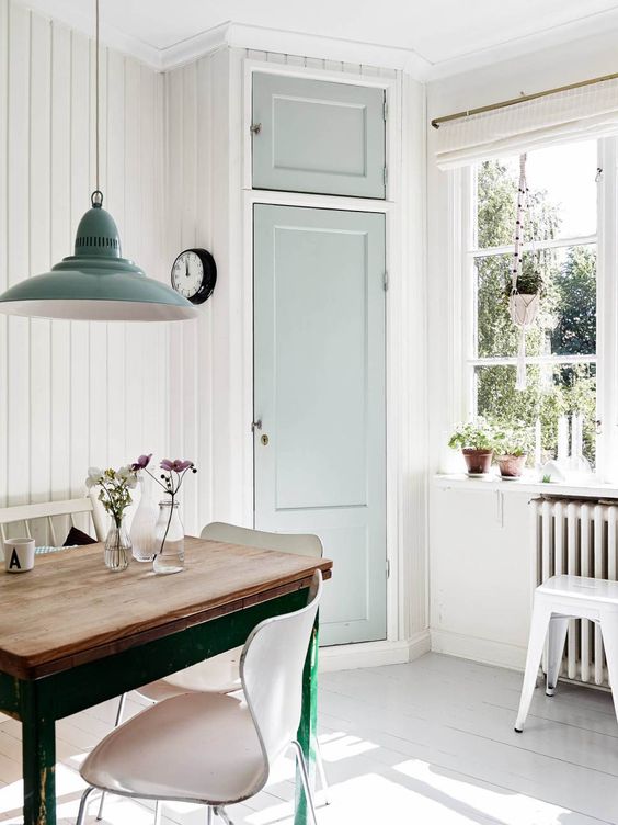 A vintage light filled space with white walls, a whitewashed floor, lots of natural light and mint touches