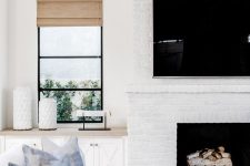 a whitewashed brick fireplace brings coziness to the neutral coastal living room and makes it cozier