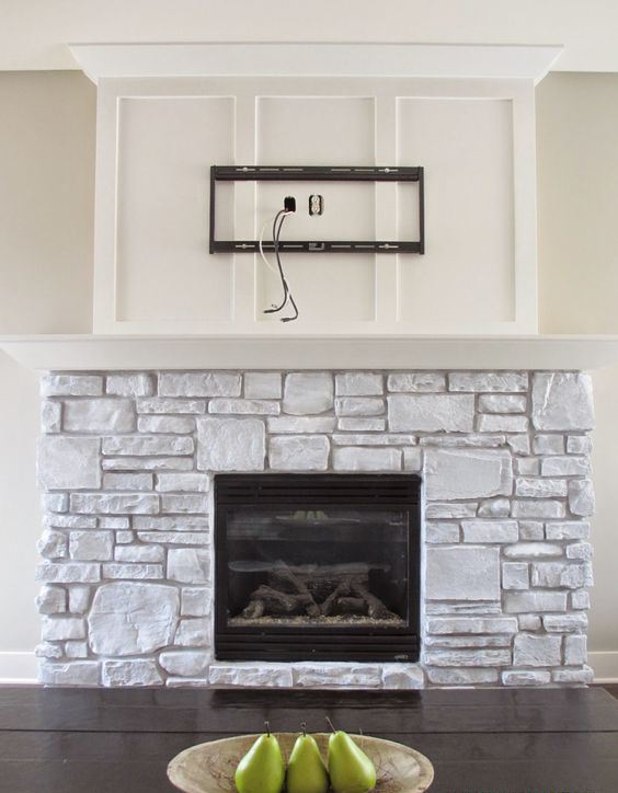 a whitewashed stone fireplace with a white mantel and a built-in fireplace looks very cozy and very natural