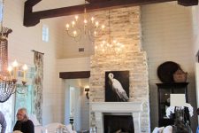 a whitewashed stone fireplace with an elegant white mantel and an artwork makes a statement in this farmhouse space