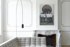 an all-white French style living room done right with a light grey sofa and some touches of black for a bit of drama