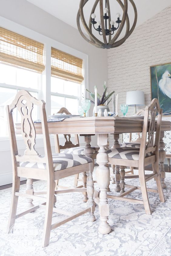 an elegant vintage whitewashed dining table and matching chairs with printed seats are ideal for a farmhouse dining space