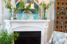 a bright summer mantel with a chevron mirror frame, blue jars with greenery arrangements, starfish and seashells