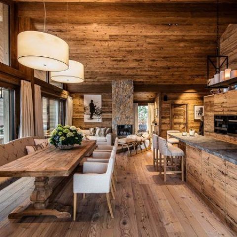 a chalet space fully clad with wood, with wooden cabinets, stone countertops and pendant lamps and candles
