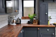 a graphite grey farmhouse kitchen finished with rich stained butcherblock countertops looks ultimately chic and bold
