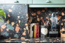 a green kitchen with bold terrazzo countertops and a backsplash is a fun and bold idea to add drama to the space