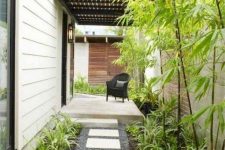 a low-maintenance front yard with pebbles, tiles, greenery and bamboo is a lovely idea for a modern home