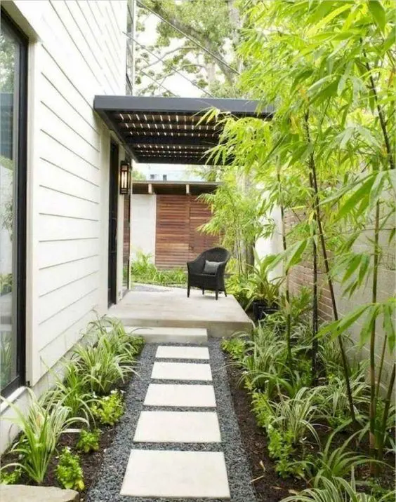 a low-maintenance front yard with pebbles, tiles, greenery and bamboo is a lovely idea for a modern home