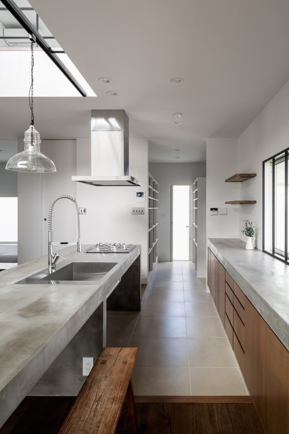 a minimalist kitchen with sleek wooden cabinets and a concrete countertop plus a concrete kitchen island