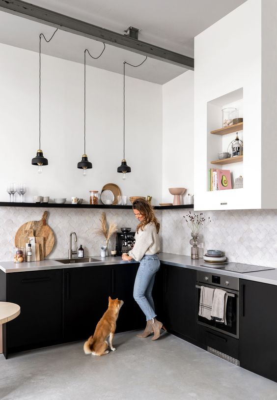 a monochromatic kitchen with black cabinets, a concrete countertop and a grey tile backsplash