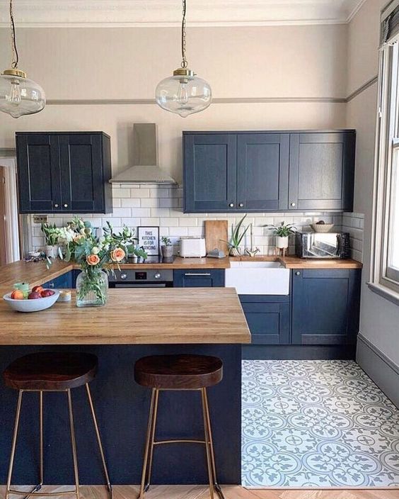 a navy farmhouse kitchen with light stained wooden countertops that soften the look and make it bolder