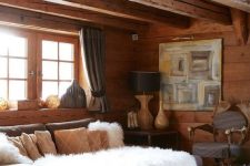a refined chalet living room with walls, a ceiling and a floor of wood, neutral furniture and vintage lamps