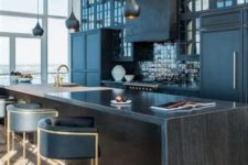 a stylish dark wood kitchen countertop matches the moody kitchen with black glossy tiles and adds chic to the space