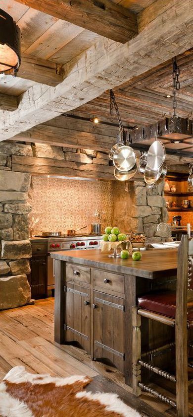 a vintage chalet kitchen with a tile backsplash, stone walls, a wooden ceiling and a large stained kitchen island