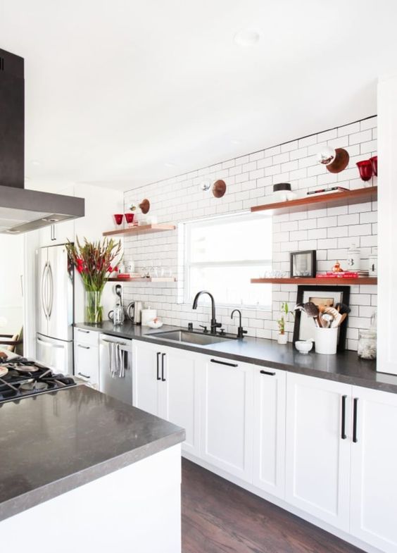 a white farmhouse kitchen with concrete countertops, black handles and appliances is very cool
