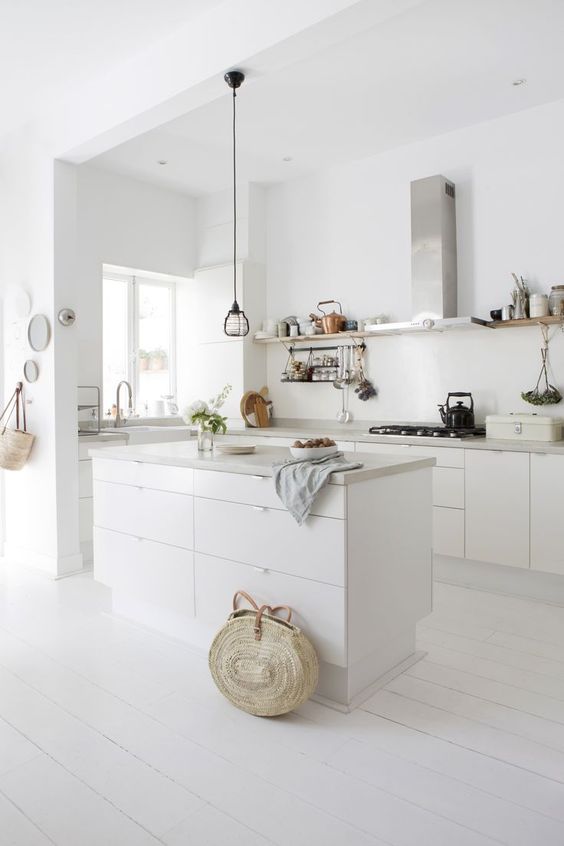 a white minimalist kitchen with sleek cabinets, concrete countertops, stainless steel appliances