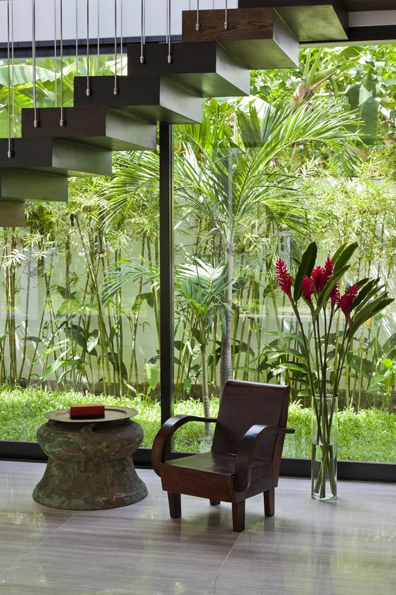 an indoor courtyard enclosed in glass, with lots of greenery and grass growing is a cool idea to refresh the spaces