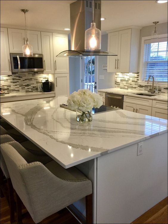 Elegant neutral stone countertops complement the white kitchen and make it bolder and more eye catching