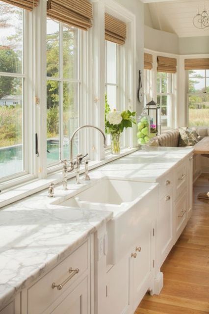 elegant white vintage-inspired cabinets plus white stone countertops that add chic to the kitchen
