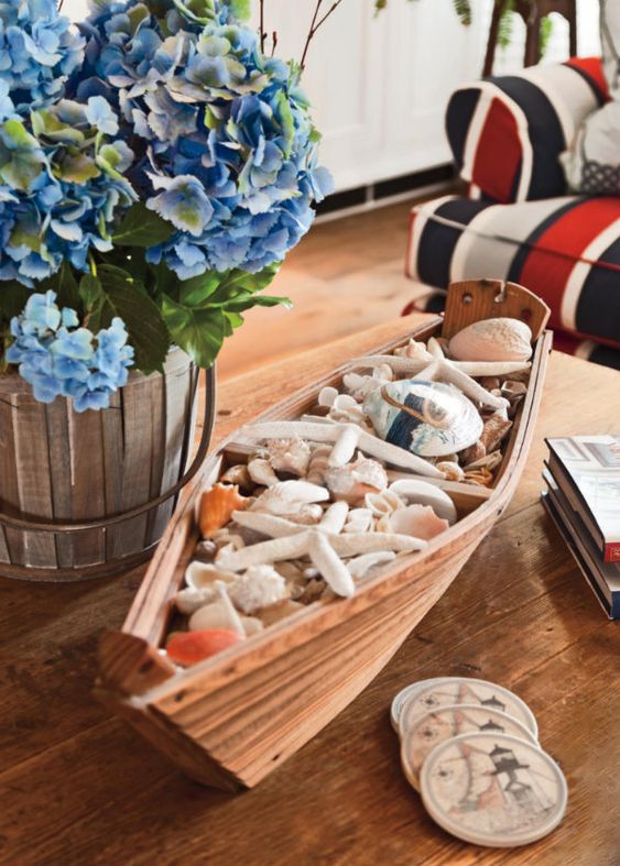 a boat filled with seashells and starfish is a nice decoration for any seaside space