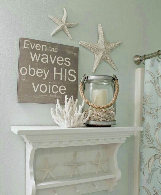 a coastal bathroom with starfish, corals and a candle lantern and with a shelf with starfish feels very cool and very stylish